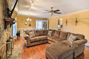 a living room with a couch and a fireplace at Lakefront Macon Home with Pool, Dock and Fire Pit! in Macon