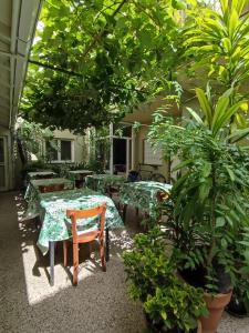 un patio con mesas, sillas y plantas en Hotel O Sole Mio en Mar del Plata
