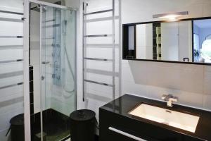 a bathroom with a sink and a glass shower at holiday home with indoor pool, Le Porge in Le Porge +25 photos