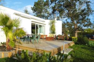 un patio con mesa y sillas en una terraza de madera en holiday home with indoor pool, Le Porge en Le Porge