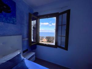 a bedroom with a window with a view of the ocean at Apartamentos El Bergantin Menorca Club in Fornells