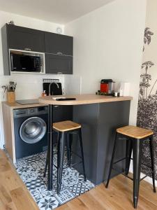 une cuisine avec un comptoir, un lave-linge et des tabourets dans l'établissement Studio 150 m de plage Golfe de Saint-Tropez, à Cavalaire-sur-Mer