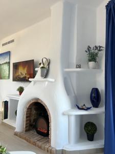 a fireplace in a living room with a white wall at Apartamentos El Bergantin Menorca Club in Fornells