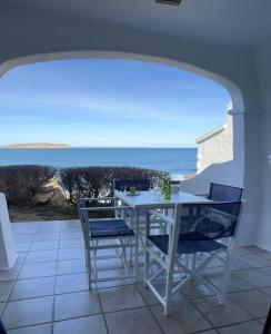 a white table and chairs with a view of the ocean at Apartamentos El Bergantin Menorca Club in Fornells