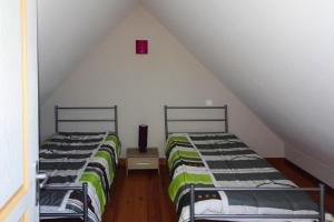 two beds in a attic room with a red box at Cottage, Guerlesquin in Guerlesquin