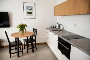 una cucina con un tavolino e un lavandino di Maya's Flats & Resorts 41 - Walowa 25 F 25 a Danzica