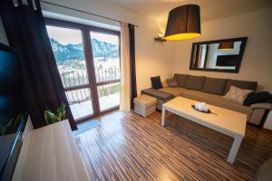 a living room with a couch and a table at Apartamenty Nad Dunajcem in Szczawnica