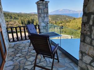 a patio with a table and a chair on a balcony at Nireas : Stone Villa in Zakynthos