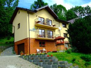 a house with a staircase in front of it at Apartamenty Nad Dunajcem in Szczawnica