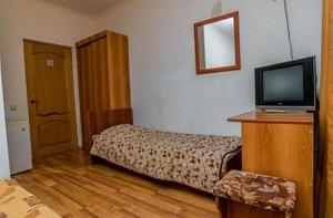 アドレルにあるMini Hotel Morskaya Skazkaのベッドとテレビが備わるホテルルームです。