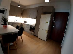 a kitchen with a white refrigerator and a table at Maklen in Athens