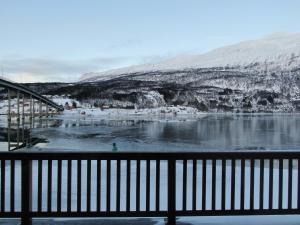 a view of a body of water with snow covered mountains at Arctic Inn in Gratangen