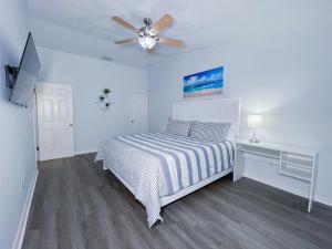 - une chambre blanche avec un lit et un ventilateur de plafond dans l'établissement So Florida getaway! Kendall Centrally located, à Miami