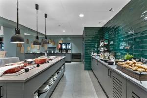 a large kitchen with a long counter with food at Grand Hotel Skei - Unike Hoteller in Skei