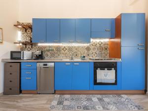 a kitchen with blue cabinets and a refrigerator at Villa Chiara Solanas in Solanas
