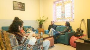 un grupo de personas sentadas en una sala de estar jugando un videojuego en Quintal Hostel & Bar en São Paulo