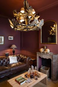 sala de estar con sofá de cuero y lámpara de araña en Mansion9Bruges en Brujas