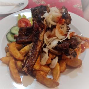 a plate of food with french fries and meat at Lesní Restaurace Harrachovka in Tábor
