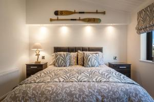 a bedroom with a bed with a surfboard on the wall at Hiraeth - Luxury Lodge with Hot Tub, Close to Beach in Penally