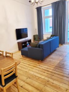 a living room with a blue couch and a tv at Centrum Apartament Stylowy in Świdnica