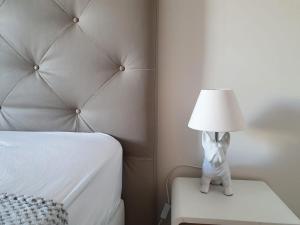 um candeeiro sentado numa cadeira ao lado de uma cama em 2BDR Reine Astrid em Cannes