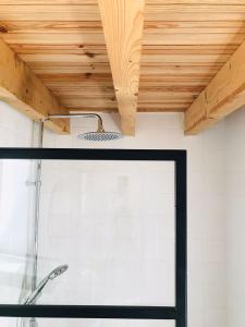 uma casa de banho com um chuveiro e um tecto em madeira em Estudio do Loureiro na Vidigueira