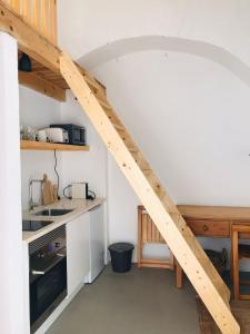 uma cozinha com uma escada de madeira num quarto em Estudio do Loureiro na Vidigueira