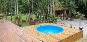 a wooden deck with a blue swimming pool on top of it at Recanto Della Mata in Venda Nova do Imigrante