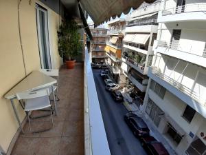 un apartamento con balcón con coches aparcados en una calle en Maklen en Atenas