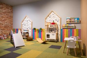 una sala de juegos para niños con cocina, mesa y sillas en Baltic Time - Domki & Spa, en Ostrowo