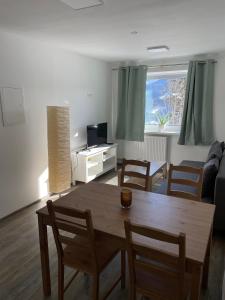 sala de estar con mesa de madera y sillas en Mountain View Apartment, en Ramsau am Dachstein