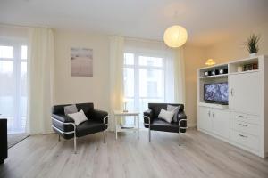 a living room with two chairs and a television at Haffblick Wohnung 43 in Boltenhagen