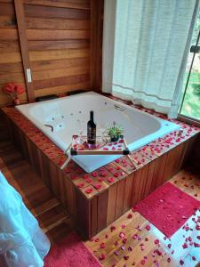 a bath tub with a bottle of wine and glasses in it at Recanto Della Mata in Venda Nova do Imigrante
