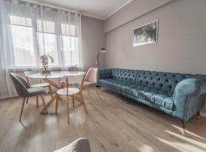 uma sala de estar com um sofá verde e uma mesa em Krosna Street Apartament em Gdansk