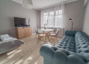 salon z niebieską kanapą i stołem w obiekcie Krosna Street Apartament w Gdańsku