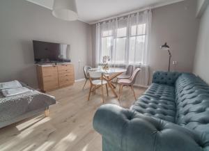 a living room with a blue couch and a table at Krosna Street Apartament in Gdańsk