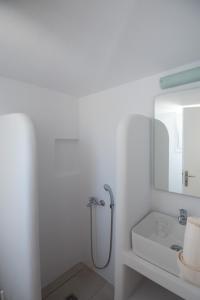 a white bathroom with a shower and a sink at Katerina Rooms in Naousa