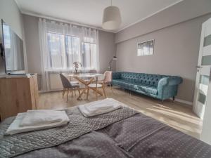uma sala de estar com um sofá e uma mesa em Krosna Street Apartament em Gdansk