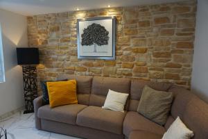 un soggiorno con divano marrone e parete in mattoni di Lovely Nature a Berck-sur-Mer
