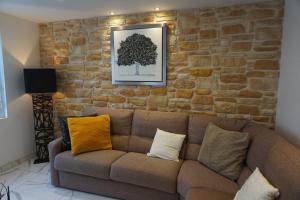a living room with a brown couch and a brick wall at Lovely Nature in Berck-sur-Mer