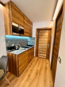 - une cuisine avec des placards en bois et un comptoir dans l'établissement Cozy studio apartment (110), à Breuil-Cervinia