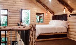 ミラーズバーグにあるTreehouse #2 by Amish Country Lodgingの丸太小屋のベッドのある寝室