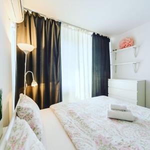 1 dormitorio con cama blanca y ventana en 1 room 50m2 center of Obolon metro station minska, en Kiev