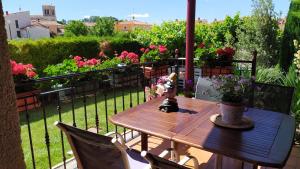 een houten tafel en stoelen op een balkon met bloemen bij Cuarenta y Ocho Luces in Burgos