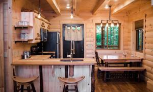a kitchen with a large island in a log cabin at Treehouse #3 by Amish Country Lodging in Millersburg