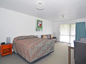 a hotel room with a bed and a couch at Celtic Motel in Foxton