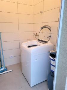 a bathroom with a white toilet with a mirror on it at Casa com Piscina na Riviera São Lourenço - módulo 24 in Riviera de São Lourenço
