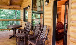 een veranda met stoelen en een tafel in een hut bij Treehouse #4 by Amish Country Lodging in Millersburg