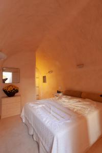 a bedroom with a large white bed in a room at Castelli Torre in Emporio Santorini