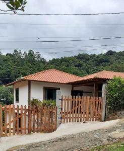 a house with a wooden fence in front of it at Casa Lumiar in Lumiar